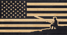 Load image into Gallery viewer, Fisherman sitting on shore holding a fishing rod engraved onto the american flag