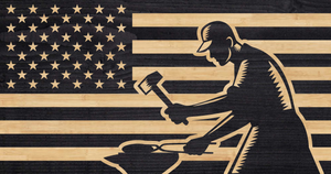 Blacksmith hammering a piece of metal overlaid on American flag